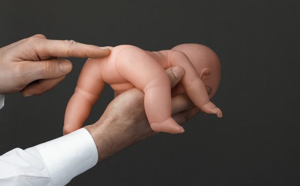 Men's hands with a baby doll - Fotó, kép