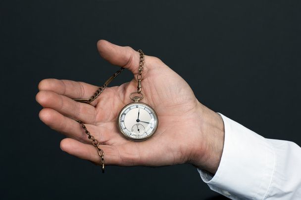 Old man's hand with a vintage clock - Foto, Bild