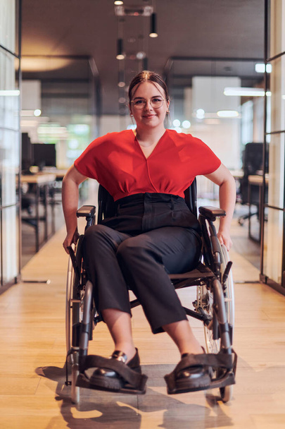 A modern young businesswoman in a wheelchair is surrounded by an inclusive workspace with glass-walled offices, embodying determination and innovation in the business world. - Фото, зображення