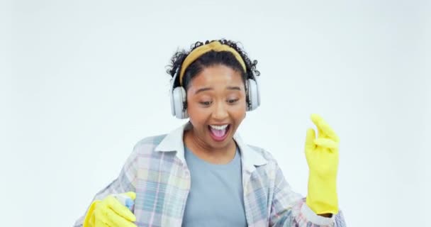 Studio, headphones and woman dance while cleaning with headphones, happy and singing on white background. Spray, cleaner and radio, podcast or music, dancing or karaoke for household spring clean. - Footage, Video