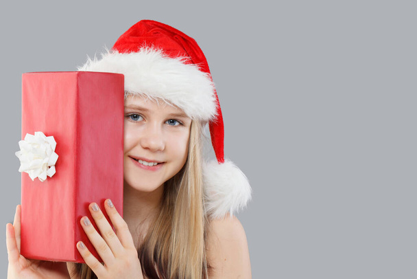Niña de Navidad adolescente Santa celebración caja de regalo roja sobre fondo gris, retrato de Navidad - Foto, Imagen