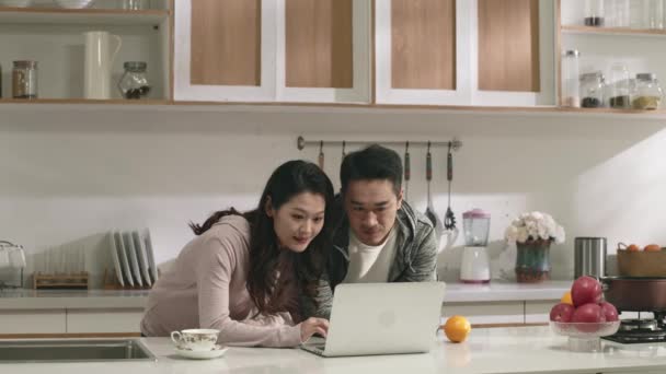 jong aziatisch paar online winkelen in keuken thuis - Video