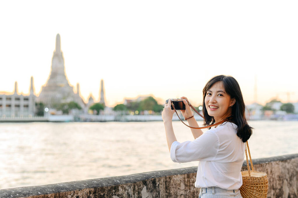 Portret mooie aziatische vrouw glimlachen tijdens het reizen op Wat Arun zonsondergang uitzicht punt, Bangkok, Thailand. - Foto, afbeelding
