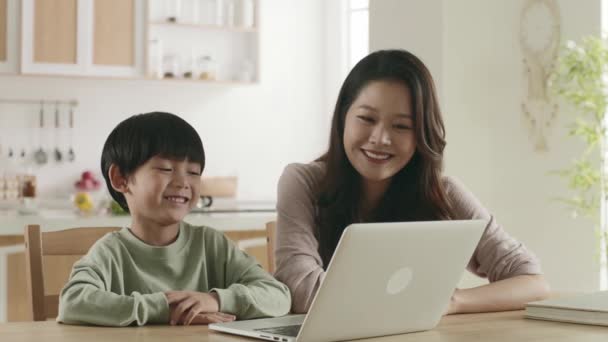 joven asiático madre viendo moviéndose con hijo en casa usando laptop ordenador - Metraje, vídeo