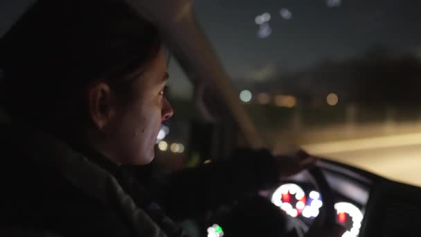 Transito concentrato di guida femminile sulla strada serale, guida concentrata della donna sulla strada notturna - Filmati, video