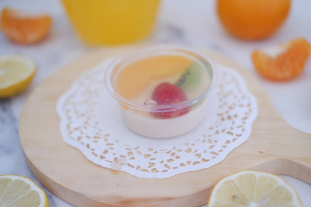 Фруктовое желе с апельсиновым соком, лимоном и киви на столе - Фото, изображение