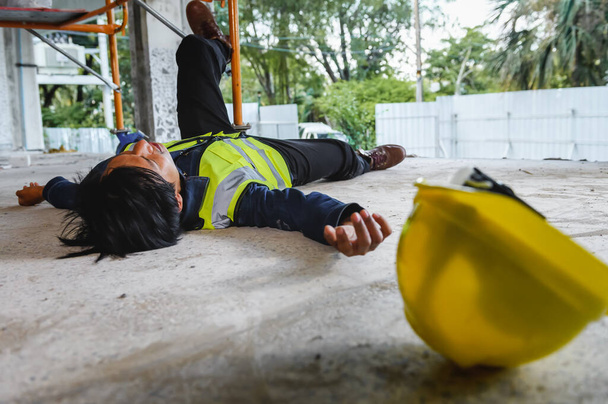 Accidente de trabajador de la construcción acostado inconsciente en el suelo después de caídas de andamios y, Accidentes de trabajo en el lugar de trabajo en el área de la obra, Concepto inseguro. - Foto, imagen
