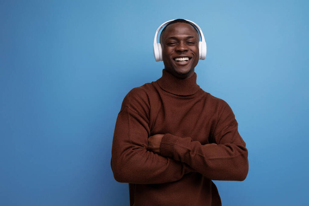 cool energetic dark-skinned american man with modern wireless headphones on the background with copy space. - Photo, image