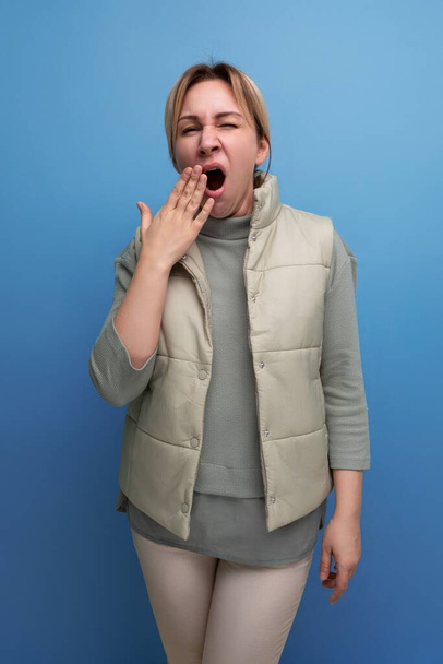 fatigué blonde 30 ans femme en vêtements décontractés bâillements couvrant sa bouche. - Photo, image