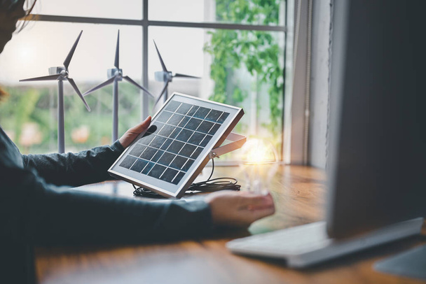 Ingenieros probando la eficiencia del tipo de paneles de células solares con luz Led en la oficina. Aprender diseño y cálculo de la acumulación de energía, utilizar la naturaleza de energía pura, solar y eólica para producir - Foto, Imagen