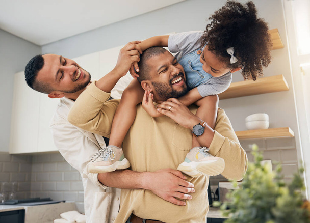 Happy family, gay parents and playing with child in home together with love, support and bonding with girl on shoulders LGBT, fathers and men with happiness, smile and dads in kitchen with kid. - Photo, Image