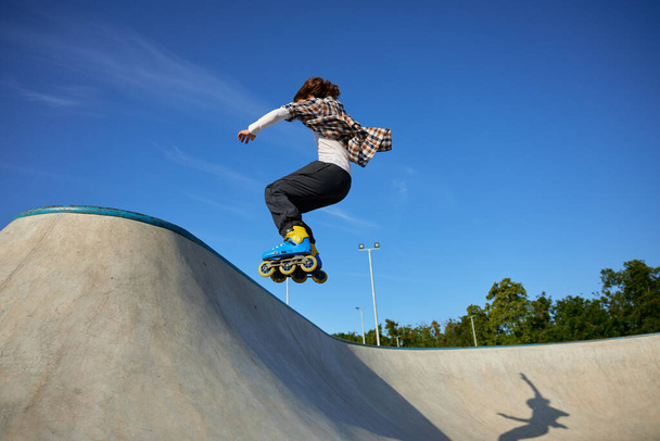 Teenager guy riding roller skates performing speed moving. Teen boy improving physical shape and skills - Foto, Imagem