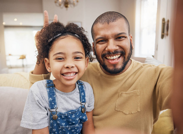 Otec, dívka a selfie portrét v mírovém znamení v obývacím pokoji, sblížení a smích dohromady. Táta, dítě a tvář úsměv v ruce na profilu obrázek, šťastná paměť nebo sociální média legrační rodiny. - Fotografie, Obrázek