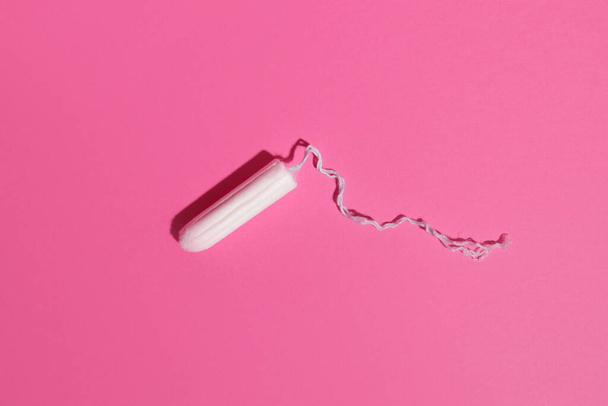 Υγιεινό θηλυκό ταμπόν σε ροζ φόντο, προϊόντα προσωπικής φροντίδας - Φωτογραφία, εικόνα