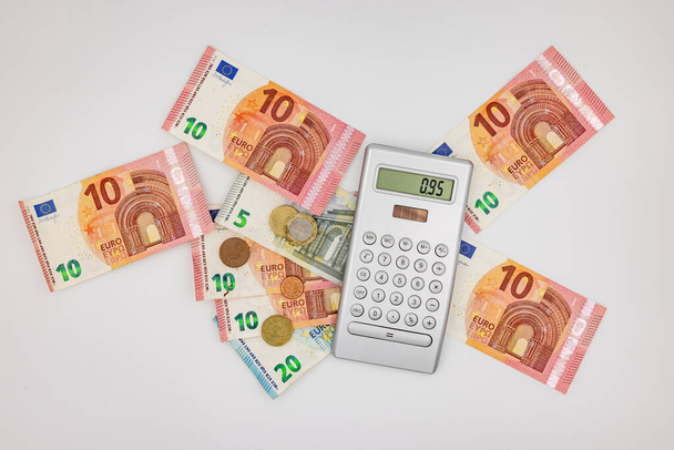 Studio top shot di una calcolatrice con banconote e monete in euro - Foto, immagini