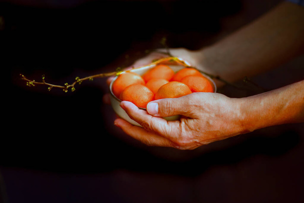 agricultor sosteniendo un tazón pequeño de mandarinas frescas - Foto, imagen