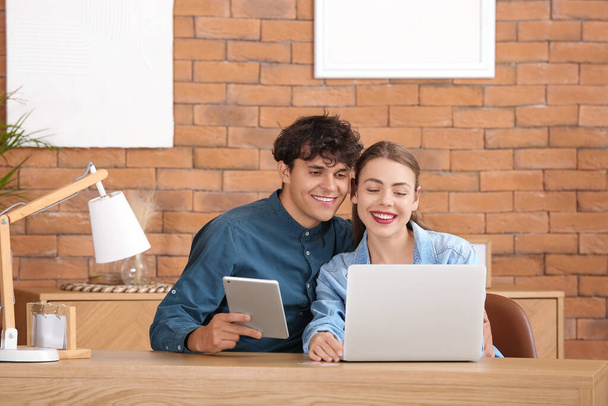 Молода пара з покупками ноутбуків онлайн вдома - Фото, зображення