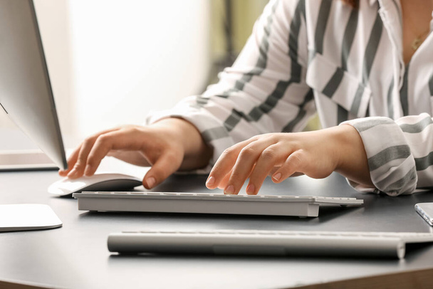 Programadora femenina escribiendo en el teclado de la computadora en su lugar de trabajo en la oficina, primer plano - Foto, imagen