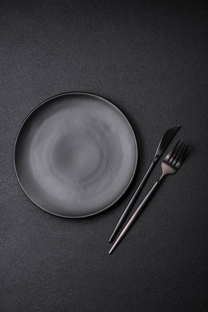Empty black plate over dark stone background with copy space. Top view - Photo, Image