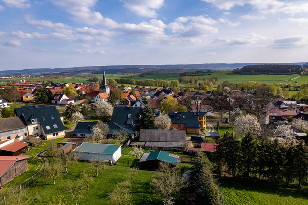 Pueblo rodeado de un hermoso paisaje verde montañoso en un colorido amanecer, imágenes aéreas. Alemania. - Foto, imagen