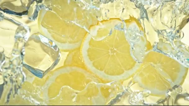 Super Slow Motion Shot of Water Wave Splashing on Lemon Slices and Ice Cubes. Filmado con cámara de cine de alta velocidad a 4K. - Imágenes, Vídeo
