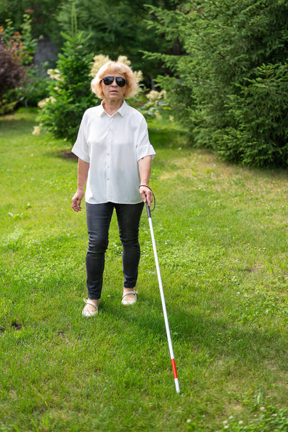 Elderly blind woman walking in the park - Фото, зображення