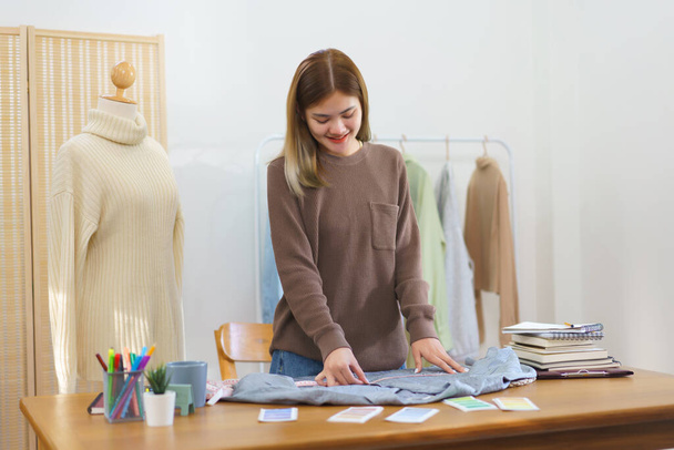 Fashion design concept, Fashion designer measuring size of shirt to checkup before sending customer. - Foto, immagini