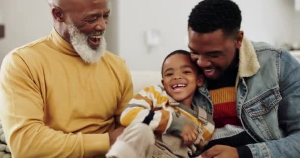 Nagyapa, apa és gyerek játszanak kanapén kötődés, kapcsolat és pihenés a nappaliban. Boldog család, játékos és afrikai nagypapa, apa és gyermek nevetnek a kanapén szórakozás, ölelés és a szeretet. - Felvétel, videó