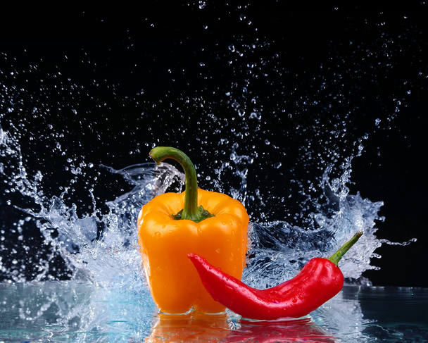 Pepper in spray of water. Juicy pepper with splash on black background - Photo, Image