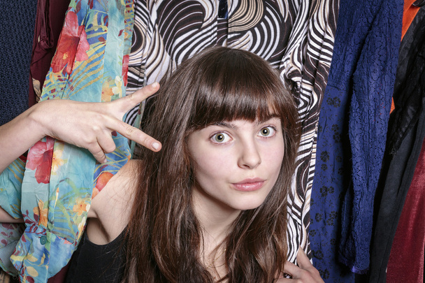 teenage girl with her wardrobe showing  a scissors with one hand - Photo, Image