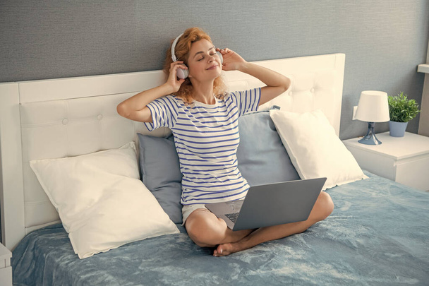 cheerful woman listen music in headphones. woman listen music at home wearing headphones. music woman with headphones. - Photo, image
