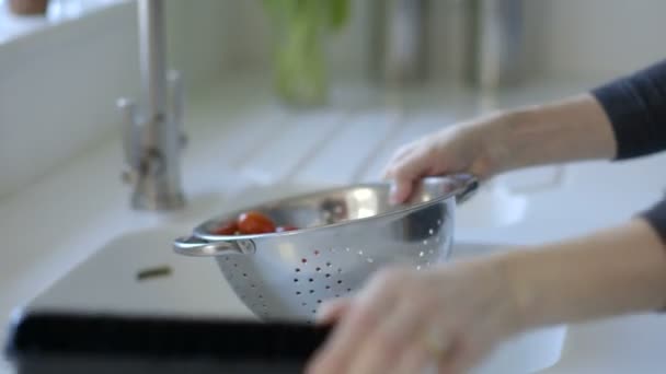 Woman washing vine tomatoes in steel colander - Záběry, video