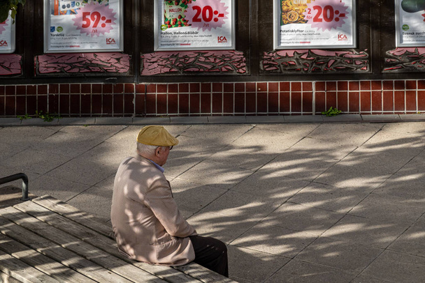 Estocolmo, Suecia Ago 15, 2023 Un hombre mayor se sienta solo fuera de un supermercado ICA en el suburbio de Axelsberg. - Foto, imagen