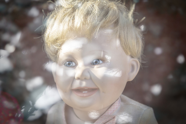 mâle tête de poupée en plastique tourné à travers une fenêtre miroir, avec bok
 - Photo, image