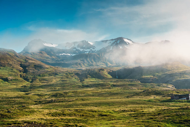 Vue paisible dans la scène rurale avec une montagne islandaise couverte de brouillard et une petite cascade dans la péninsule de Snaefellsnes en été en Islande - Photo, image
