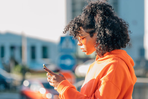afro amerikai lány az utcán a mobiltelefon - Fotó, kép