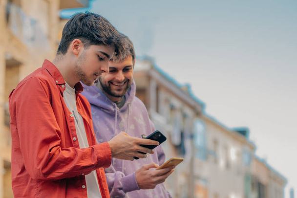 mladí lidé na ulici chatují s mobilními telefony - Fotografie, Obrázek