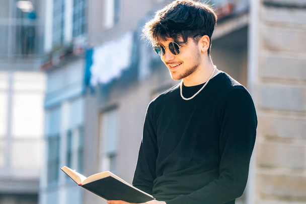 jeune homme lisant avec manuel à l'extérieur - Photo, image