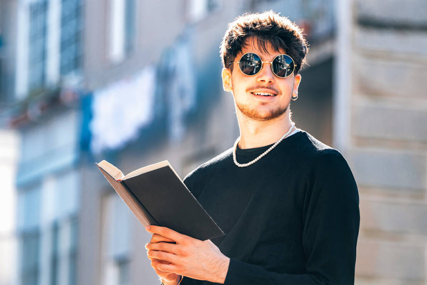 mladý muž čtení s učebnicí venku - Fotografie, Obrázek