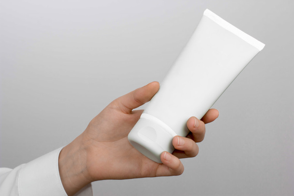 Girl's hand with white tube - Foto, afbeelding