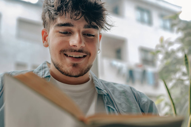 молодой человек читает книгу или учится дома - Фото, изображение