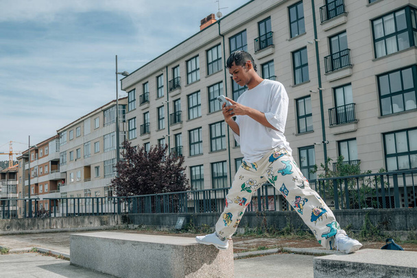 nuori latino mies matkapuhelimella kaupungin kadulla - Valokuva, kuva