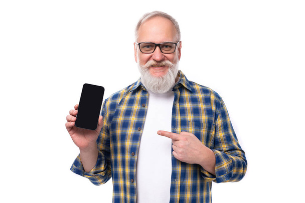 ハンサムな高齢の灰色の髪の引退した男 ひげとひげがスマートフォンを広告します. 中年ビジネス. - 写真・画像
