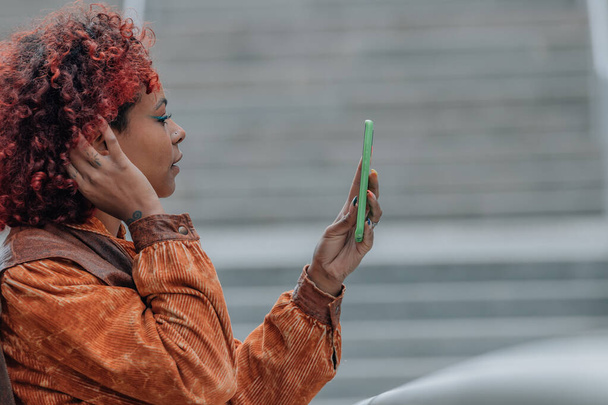 profil fille dans la rue avec téléphone portable et afro cheveux - Photo, image