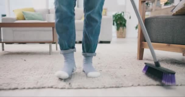 Voeten, dans en bezem met een persoon die een tapijt schoonmaakt in de woonkamer van een huis voor huishoudelijk werk. Benen, vrijheid en energie met een volwassene in een appartement close-up voor routine schoonmaak of vegen. - Video