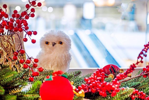 красива мила біла іграшкова сова в різдвяних гілках з декоративними прикрасами - Фото, зображення