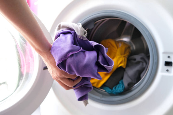 Main de femme Ramasser des vêtements Machine à laver. Concepts propres et sains - Photo, image