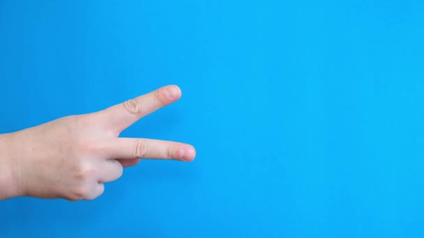 Egy férfi két ujjal mutogat egy krómozott vásznon. Győzelmi gesztus. - Felvétel, videó