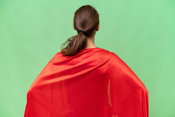 Super Hero caucasian woman over isolated background in back position - Photo, Image