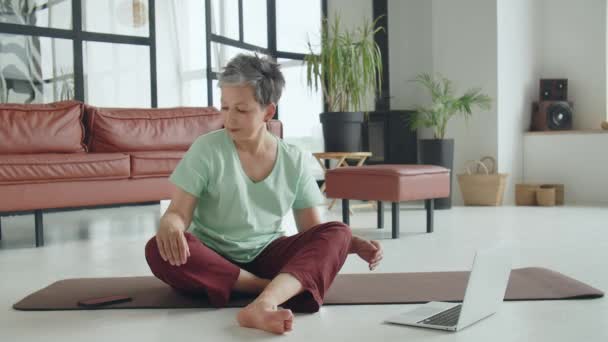 Yaşlı kadın evde yoga egzersizi yapıyor. Olgun kadınlar meditasyon yapar. Yüksek kalite 4k görüntü - Video, Çekim